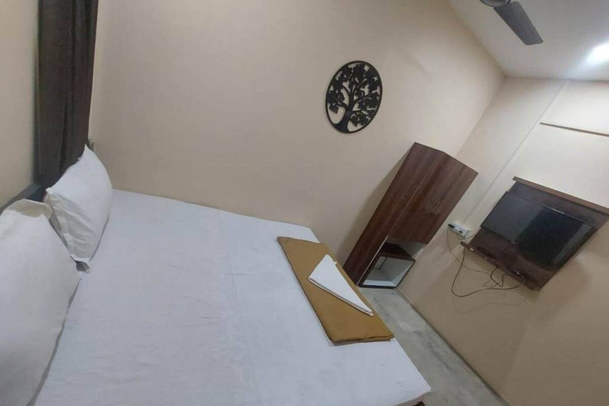 Habitació d'hotel amb un llit, una petita taula de treball, una televisió i una decoració mural.