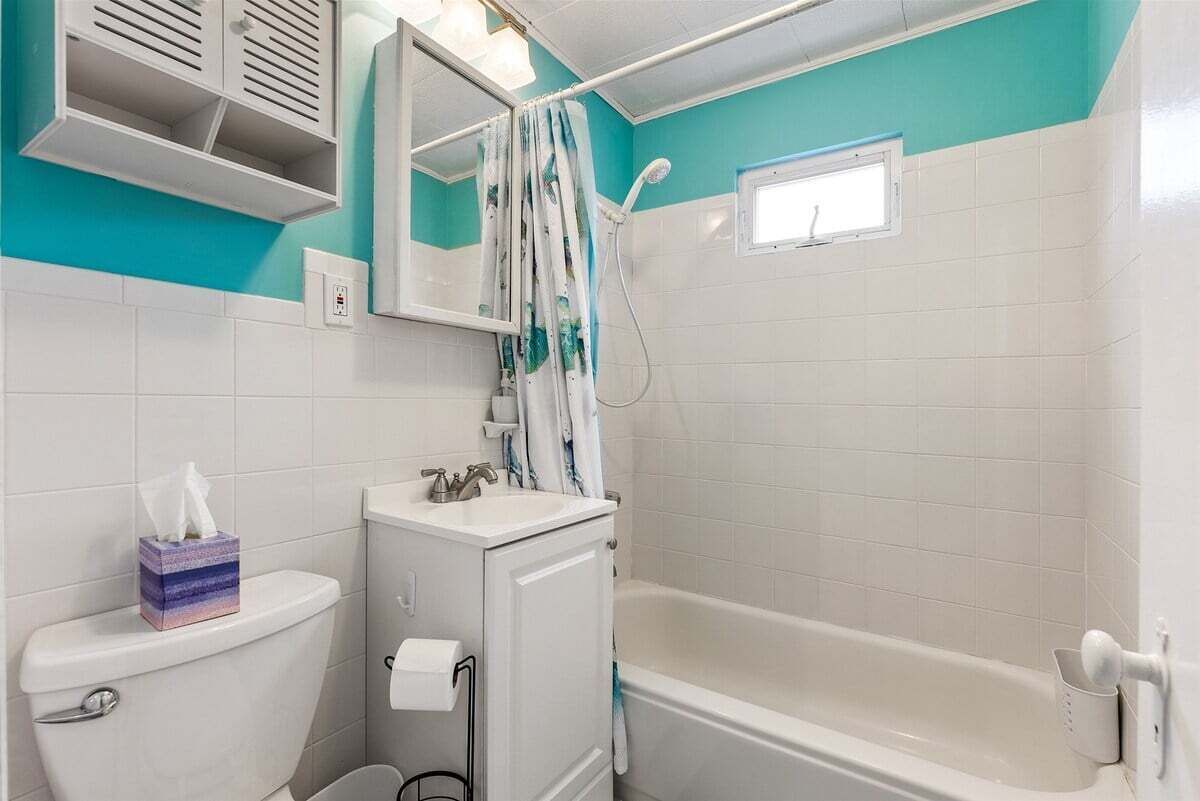 A bathroom with a toilet, sink, and bathtub.
