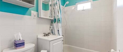 A bathroom with a toilet, sink, and bathtub.