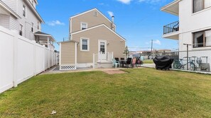 A two-story house with a covered patio, a fenced yard, and a bicycle parked outside.