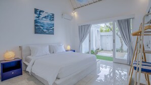 A bedroom with a bed, a nightstand, a painting, and a view through a sliding glass door. - Villa Rio (Canggu)