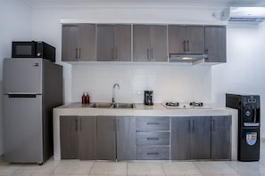 Enjoy cooking in this well-equipped kitchen with a double sink, coffee maker, and water dispenser.