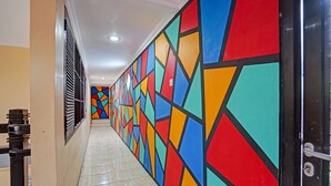 A hallway with a colorful geometric wall pattern and a tiled floor.