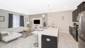 A modern kitchen with a central island, dark cabinetry, and stainless steel appliances. - Disney 4 miles *Lazy River Club* Private Pool*4B/3B (Kissimmee)