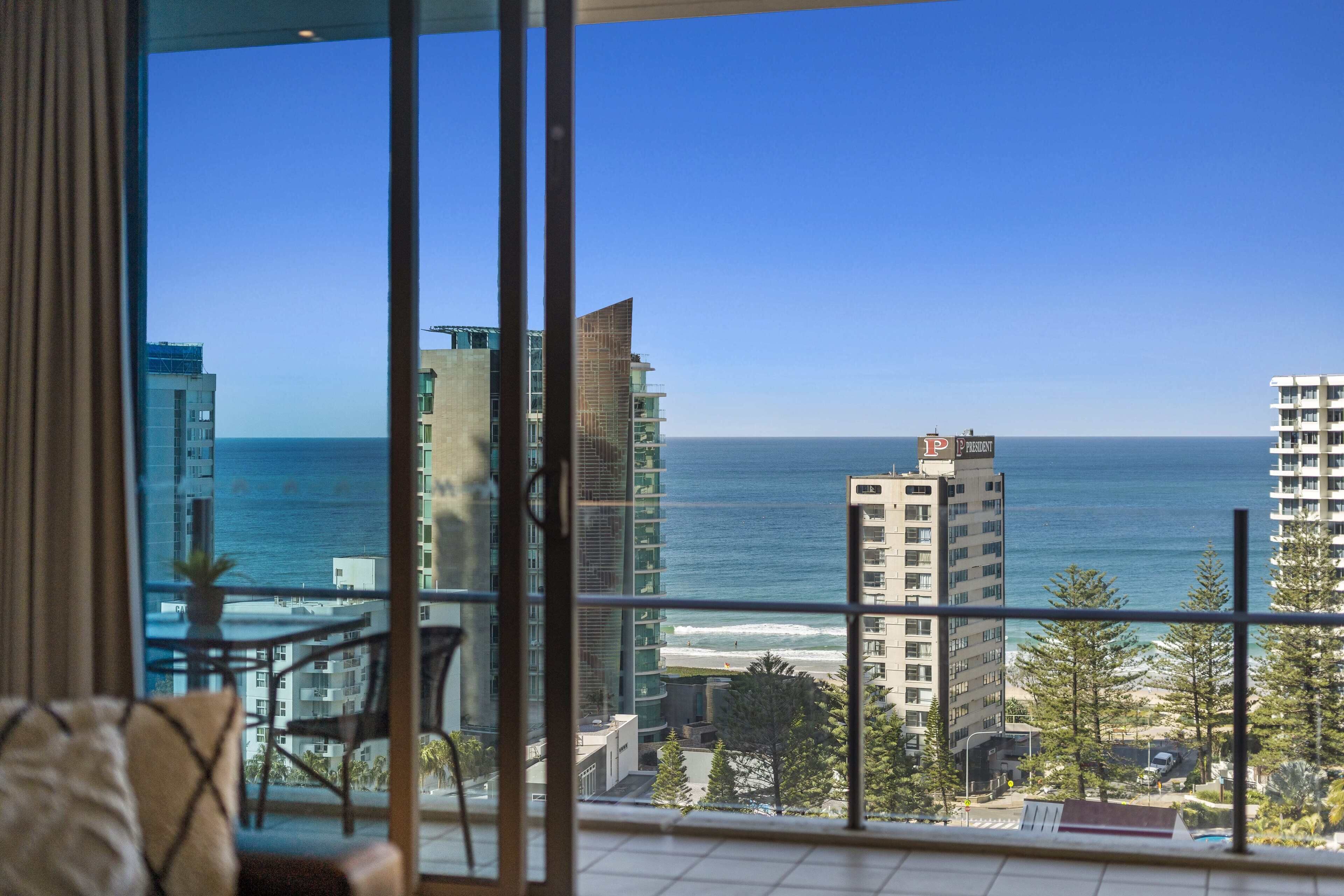 A balcony with a view of the ocean and buildings.