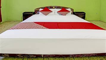 A bed with a white and red bedspread, two red pillows, and a wooden headboard.