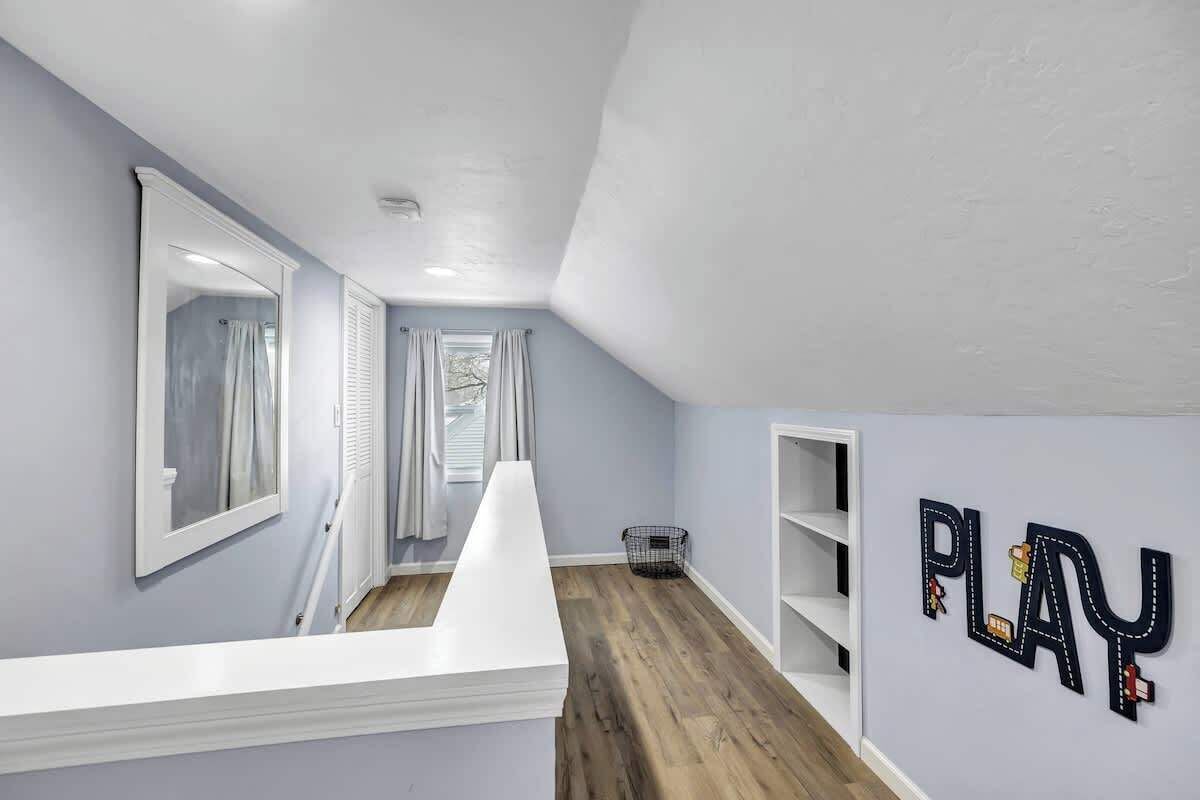 A hallway with a white reception desk, a window with curtains, and a 'PLAY' sign on the wall.