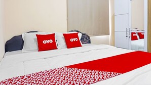 A hotel room with a bed, white and red bedding, a wardrobe, and a mirror. - OYO 91349  Karawaci Taman Permata 3 (Curug)