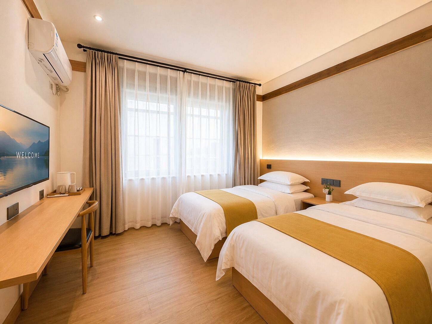 A hotel room with two beds, a desk with a TV, and a large window with curtains.