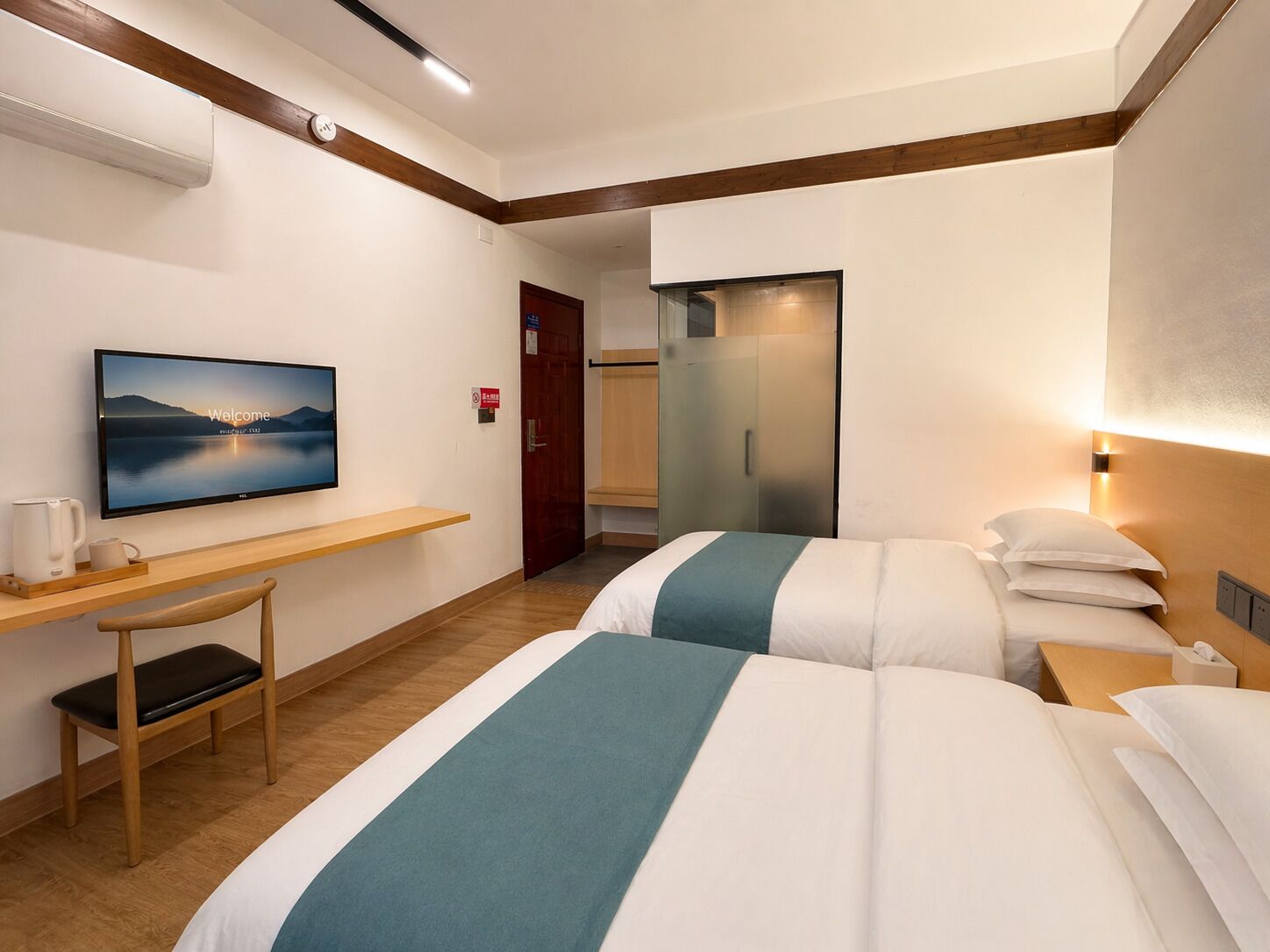 Een hotelkamer met een bed, nachtkastjes, een televisie, een bureau en een stoel.
