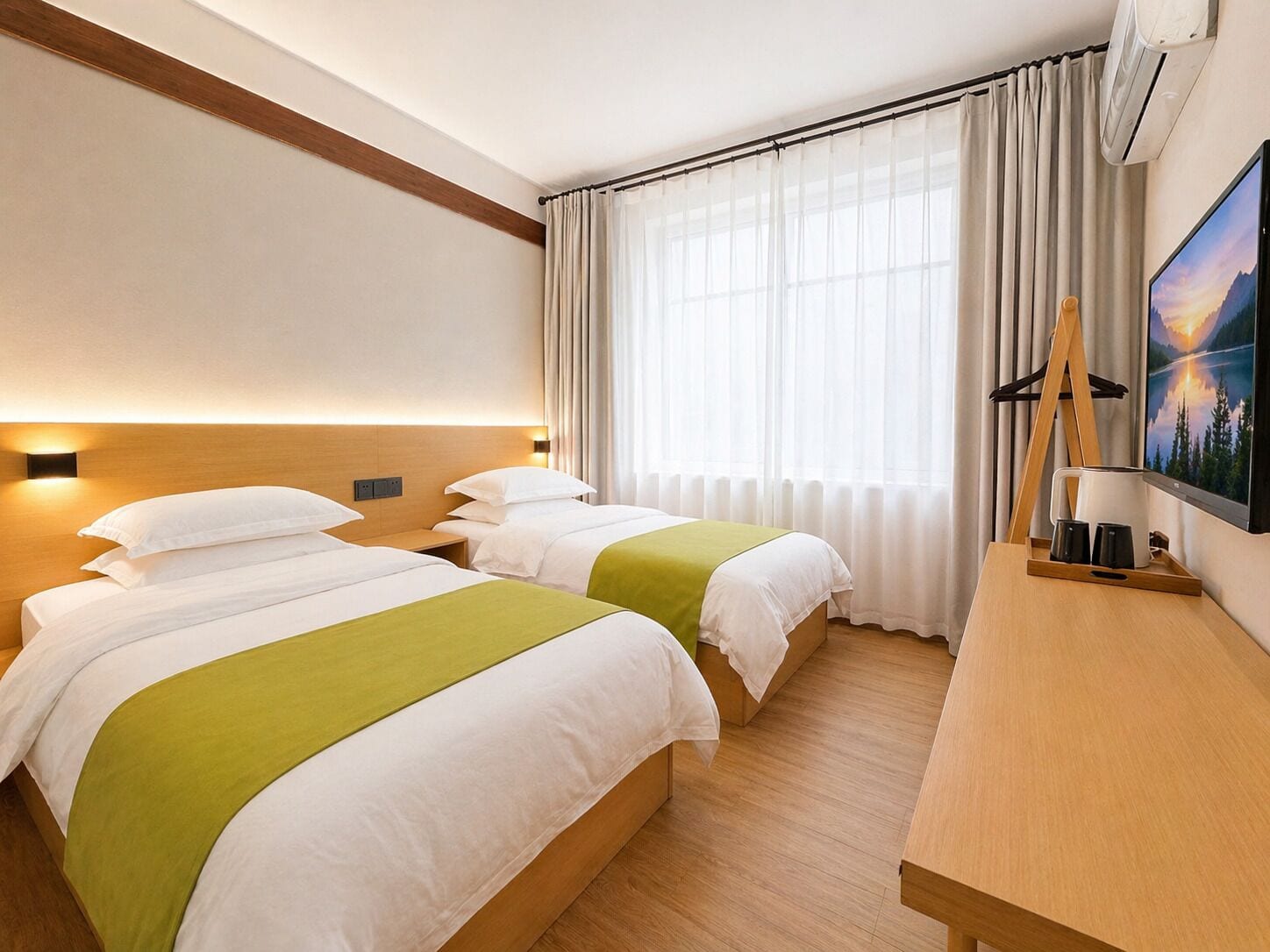 Una habitación de hotel con dos camas, un escritorio, un cuadro y un equipo de aire acondicionado.