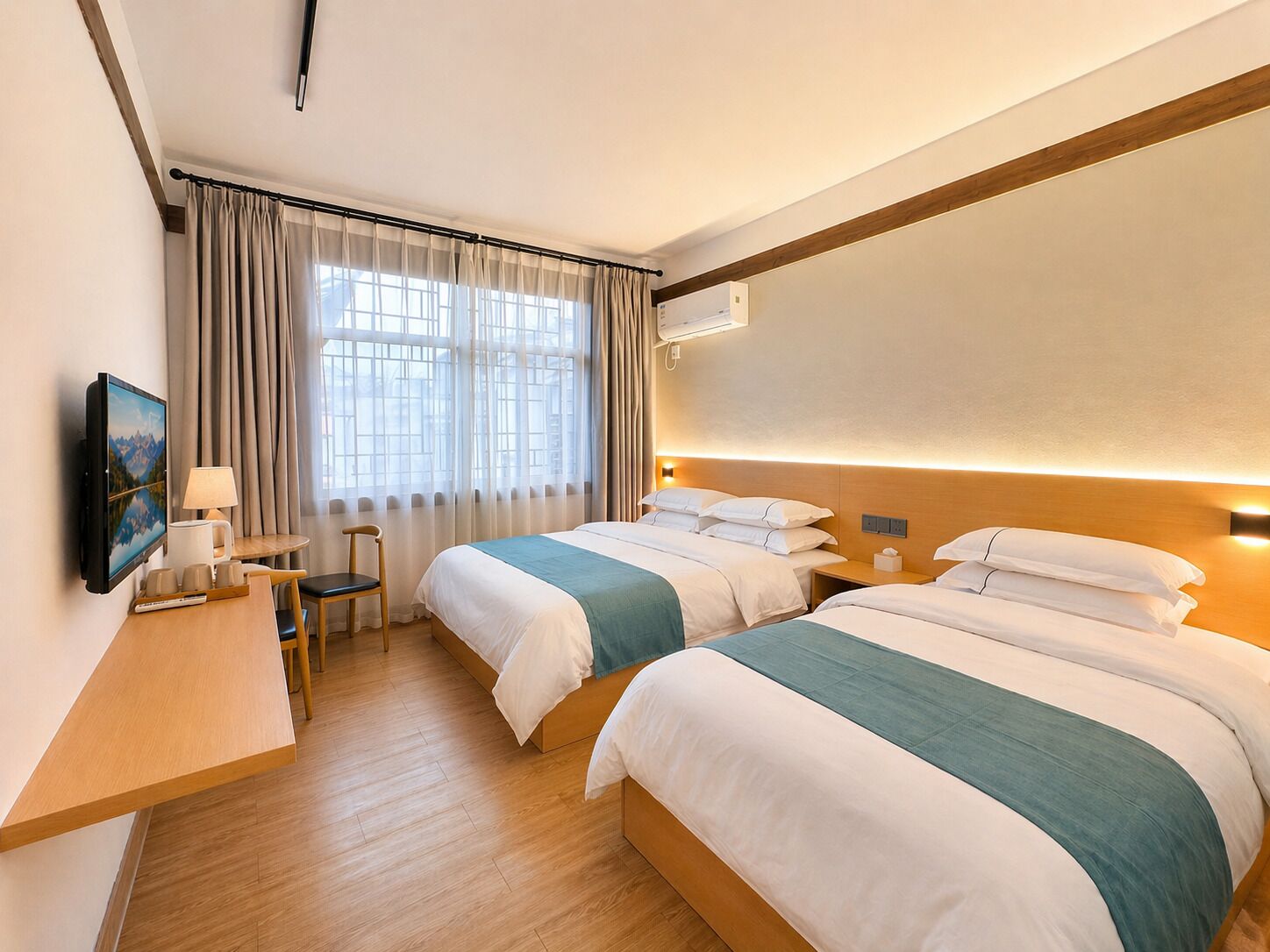 A hotel room with two beds, a desk with a chair, a TV, and a window with curtains.
