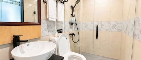 Ein modernes Badezimmer mit einem großen Waschbecken, Toilette und einer Duschkabine.
