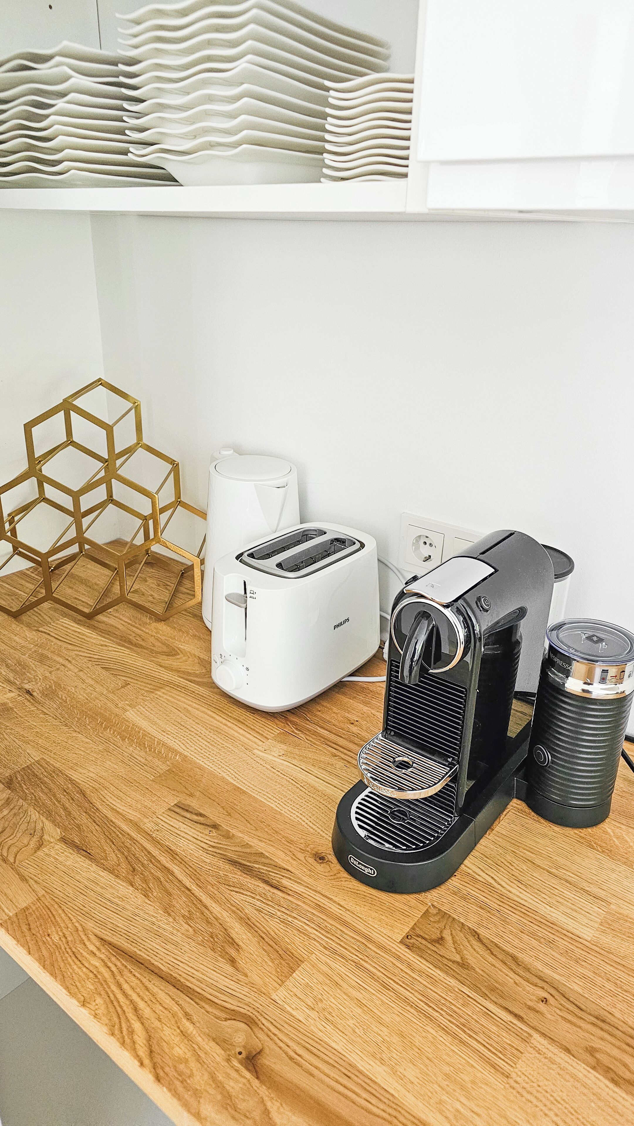 Eine Küchenarbeitsplatte mit Kaffeemaschine, Toaster und einem sechseckigen Ablagerost.