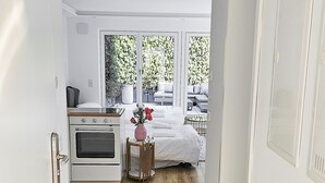 Een moderne keuken met een oven en een klein tafeltje met een vaas.