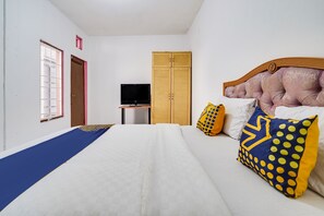 Une chambre à coucher comprenant un lit, une télévision, une armoire et une fenêtre avec des barreaux.