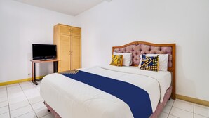 A bedroom with a bed, a television on a stand, and a wardrobe. - OYO 91546 Dewi Sudirman Homestay (Bandung)