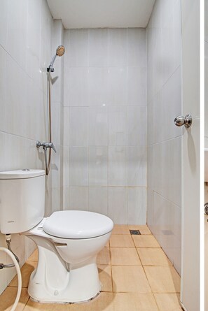 Habitación básica doble | Baño | Ducha, cabezal de ducha tipo lluvia, albornoces y bidé