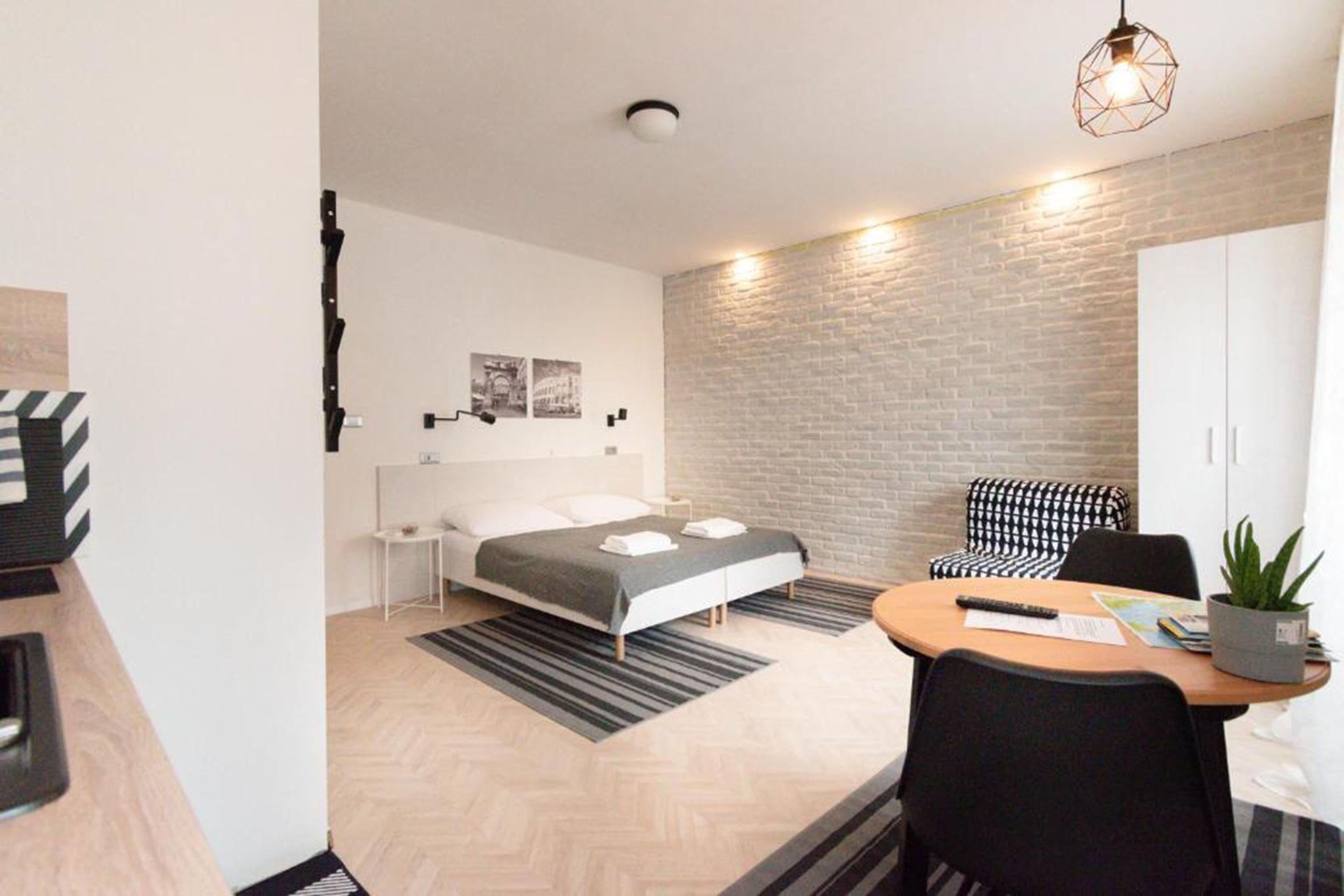 A modern bedroom with a bed, bedside tables, a desk, and a chair.