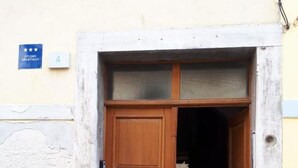 Una puerta de madera con un panel de vidrio en la parte superior, incrustada en una pared de piedra.
