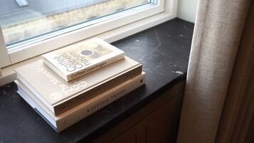 A stack of books on a black countertop near a window.