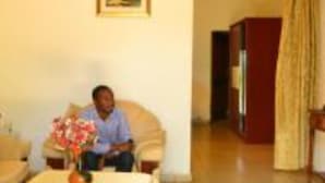 A room with a sofa, a table with a vase, and a painting on the wall.