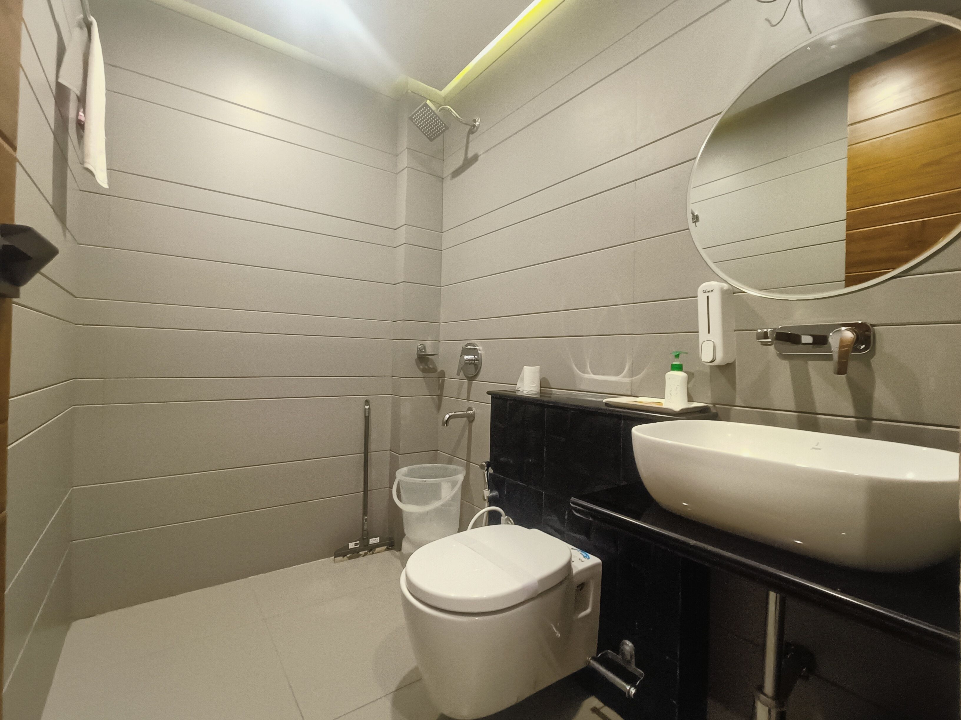 Een moderne badkamer met toilet, wastafel en douche.