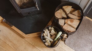 A wood stove with firewood stored nearby.