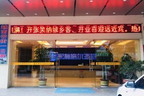 A hotel entrance with a large sign, glass doors, and potted plants. - Xilinger Hotel ( Dongxing Hezhou Road) (Dongxing)