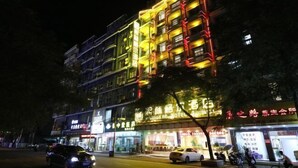 Ein mehrstöckiges Hotel mit beleuchteter Beschilderung und Balkonen.