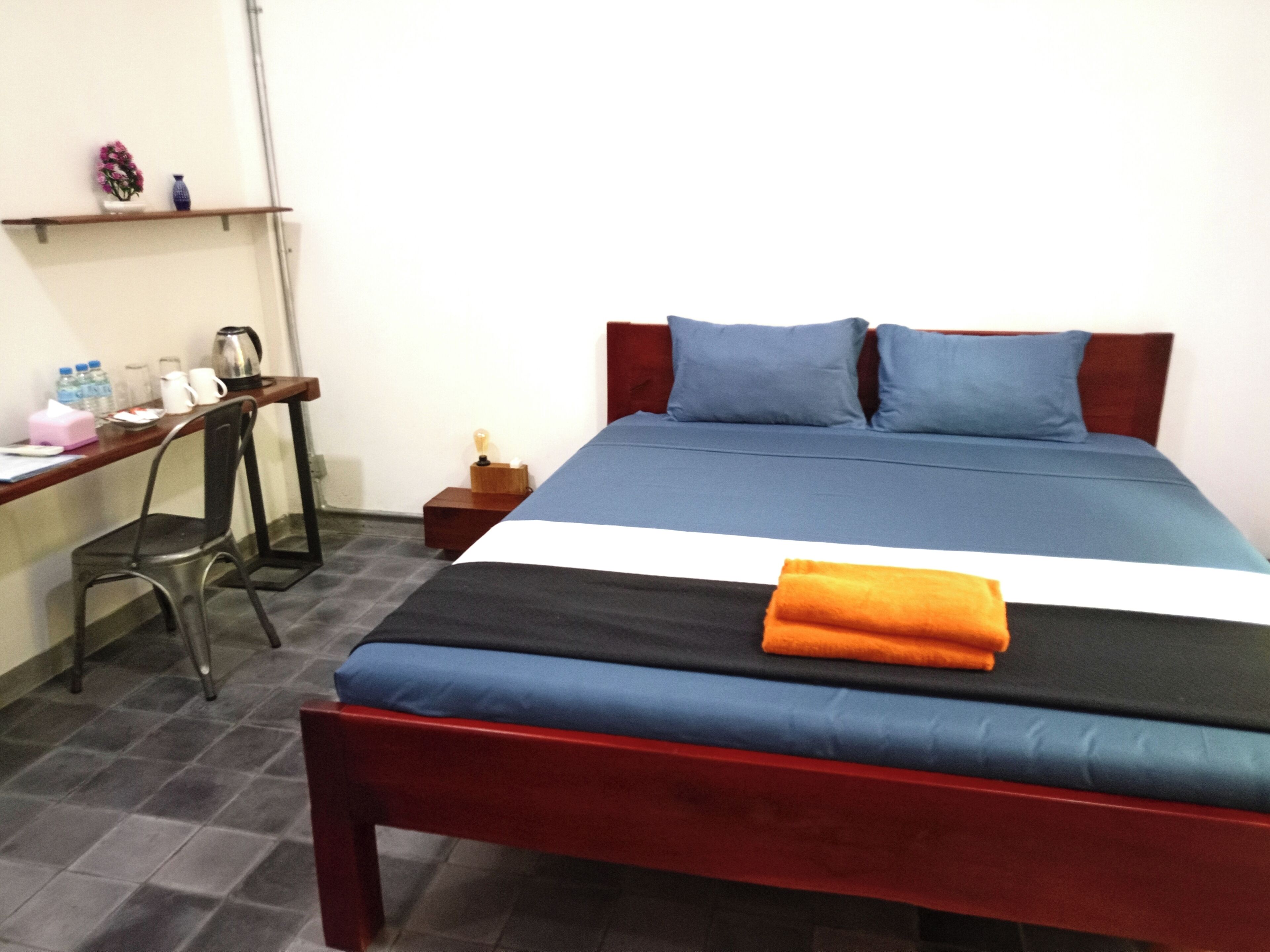 Ein Hotelzimmer mit Bett, Schreibtisch und Stuhl.