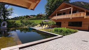 A wooden cabin with a pool and outdoor seating.