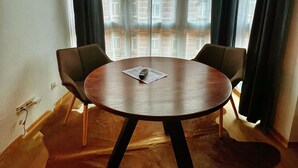 A round table with two chairs, a remote control, and a menu on the table. - Talgarten Studio 3 (Erfurt)