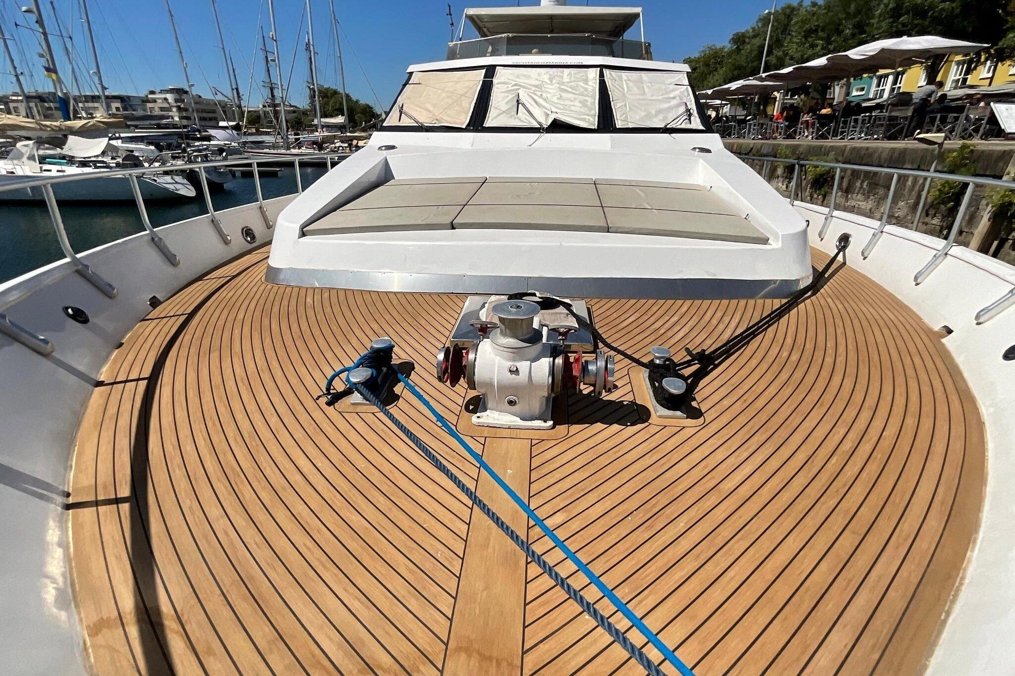 Le pont d’un yacht est doté d’une station de contrôle centrale, entourée d’un pont en bois et d’une rambarde.
