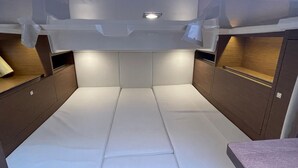 A compact, modern interior with a central seating area, wooden cabinetry, and overhead lighting. - Luxury yacht in La Rochelle with a terrace (La Rochelle)