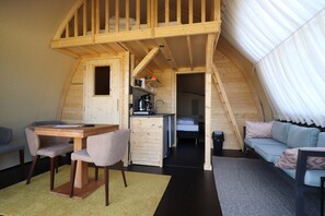 Un intérieur compact en bois comprenant un coin repas, une kitchenette et un espace nuit.