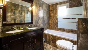 Un baño con dos lavamanos, un espejo grande y una bañera.