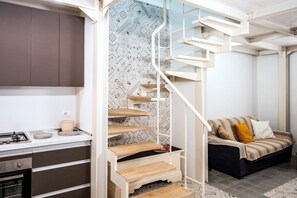 A compact living space with a kitchen, a dining area, and a sofa. - erma mare apartment (Polignano a Mare)