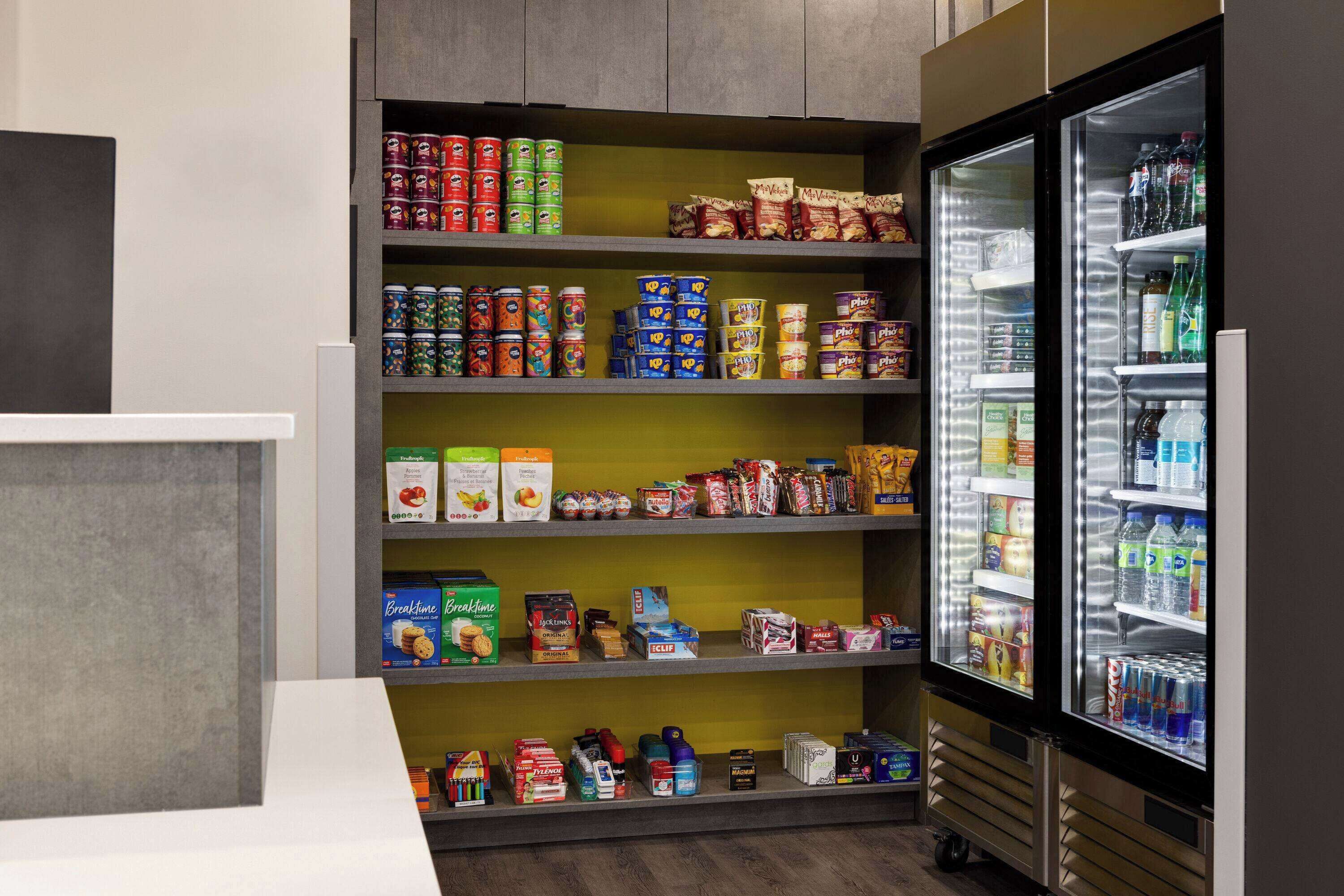 A self-service beverage station with a variety of canned and bottled drinks, and a refrigerated section with bottled water and soft drinks.