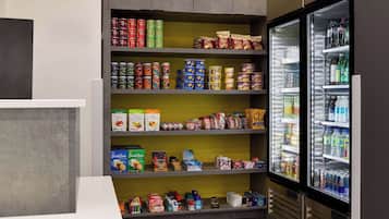 A self-service beverage station with a variety of canned and bottled drinks, and a refrigerated section with bottled water and soft drinks.