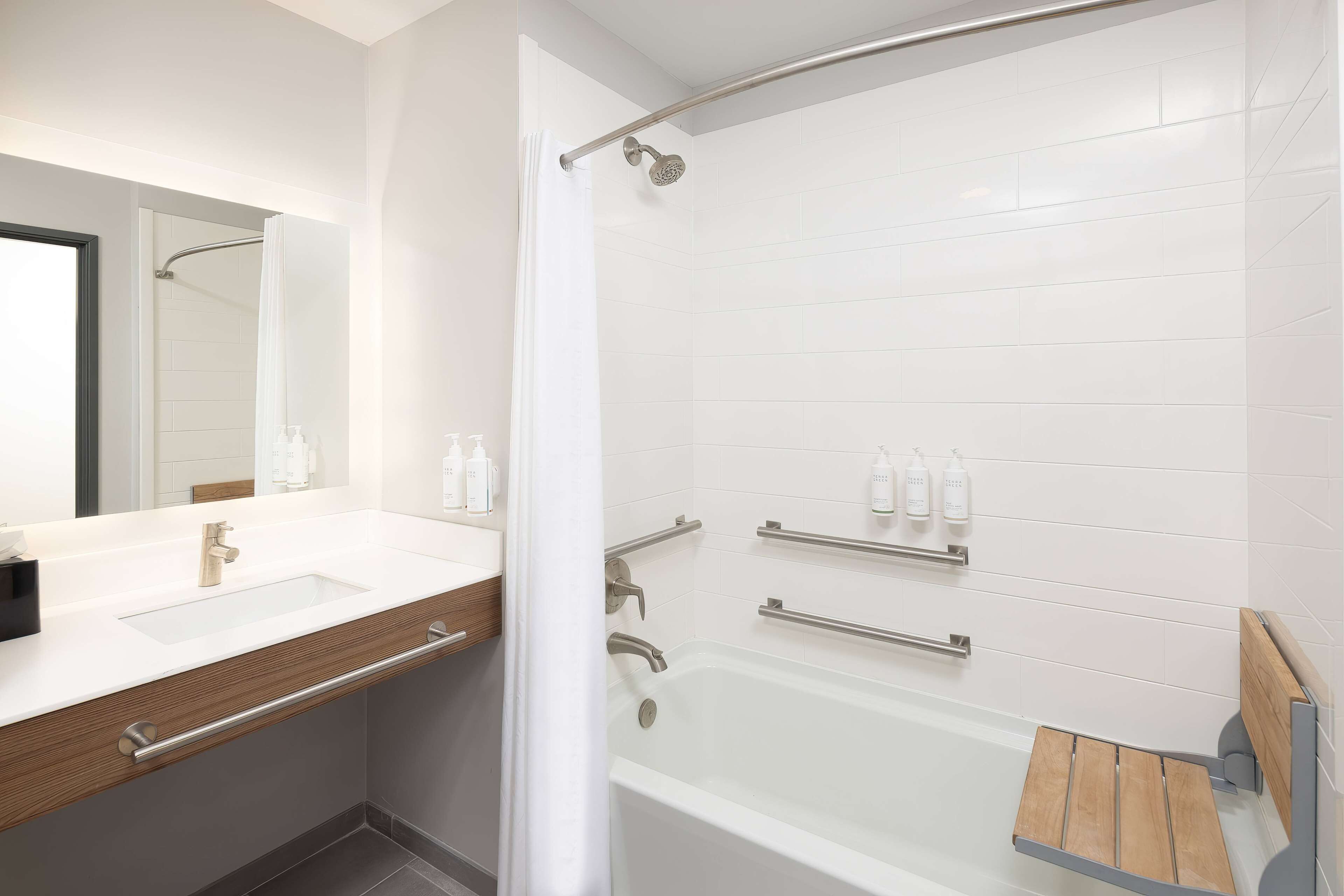 A modern bathroom with a white sink, mirror, and shower.