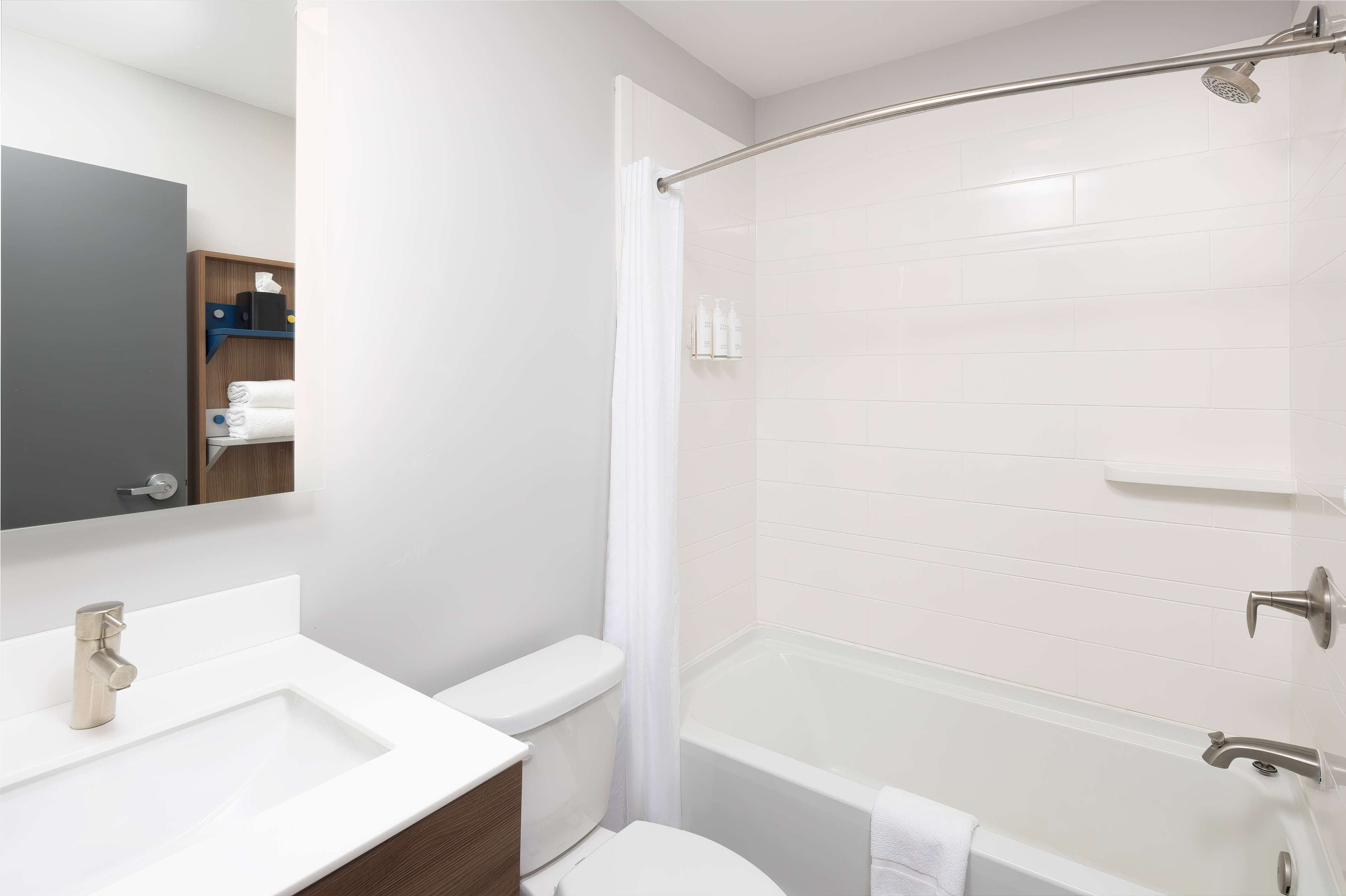 A modern bathroom with a white sink, toilet, and bathtub.