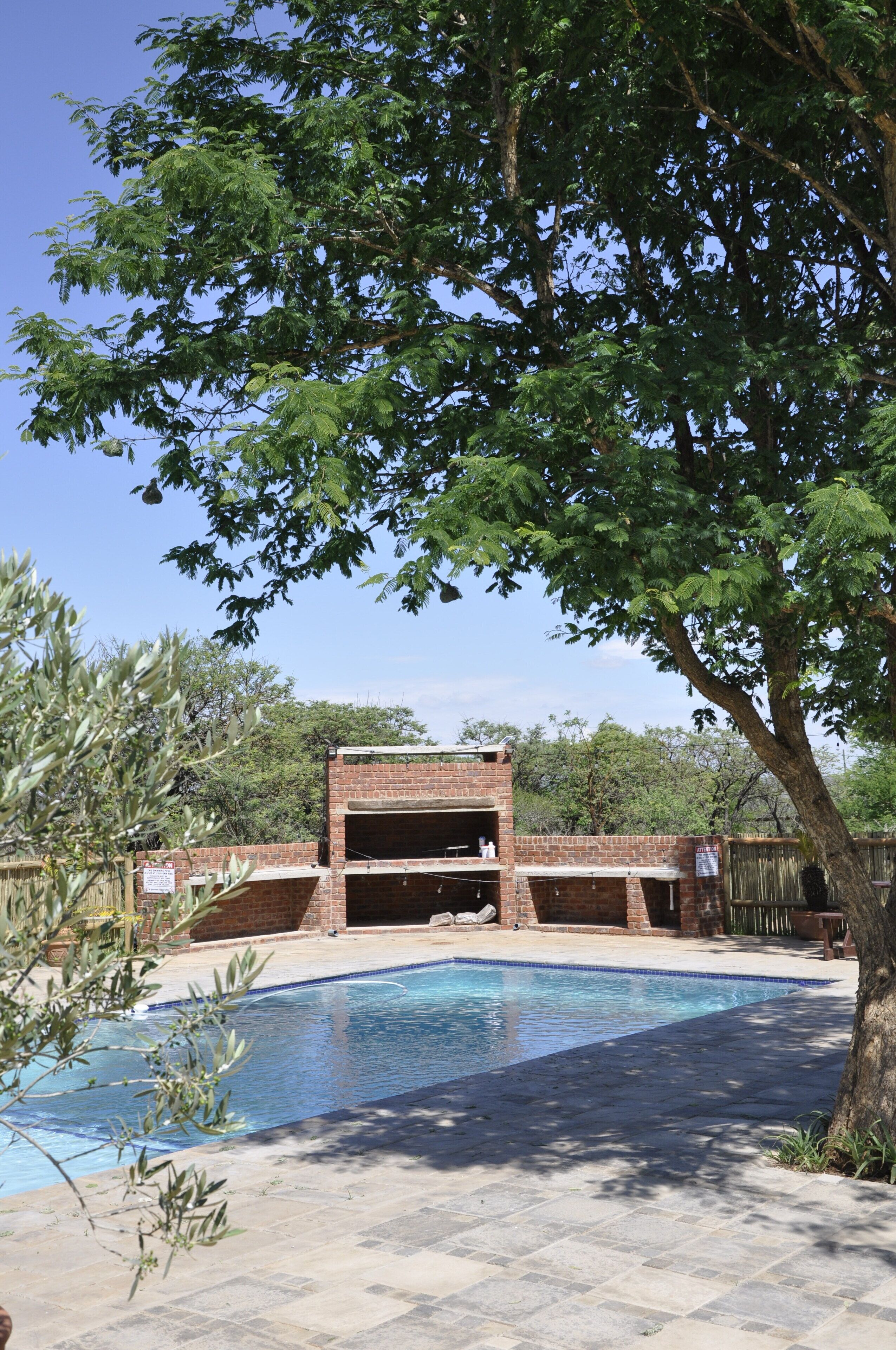 A swimming pool with a brick structure in the background.