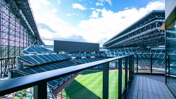 A stadium with tiered seating and a large open field.