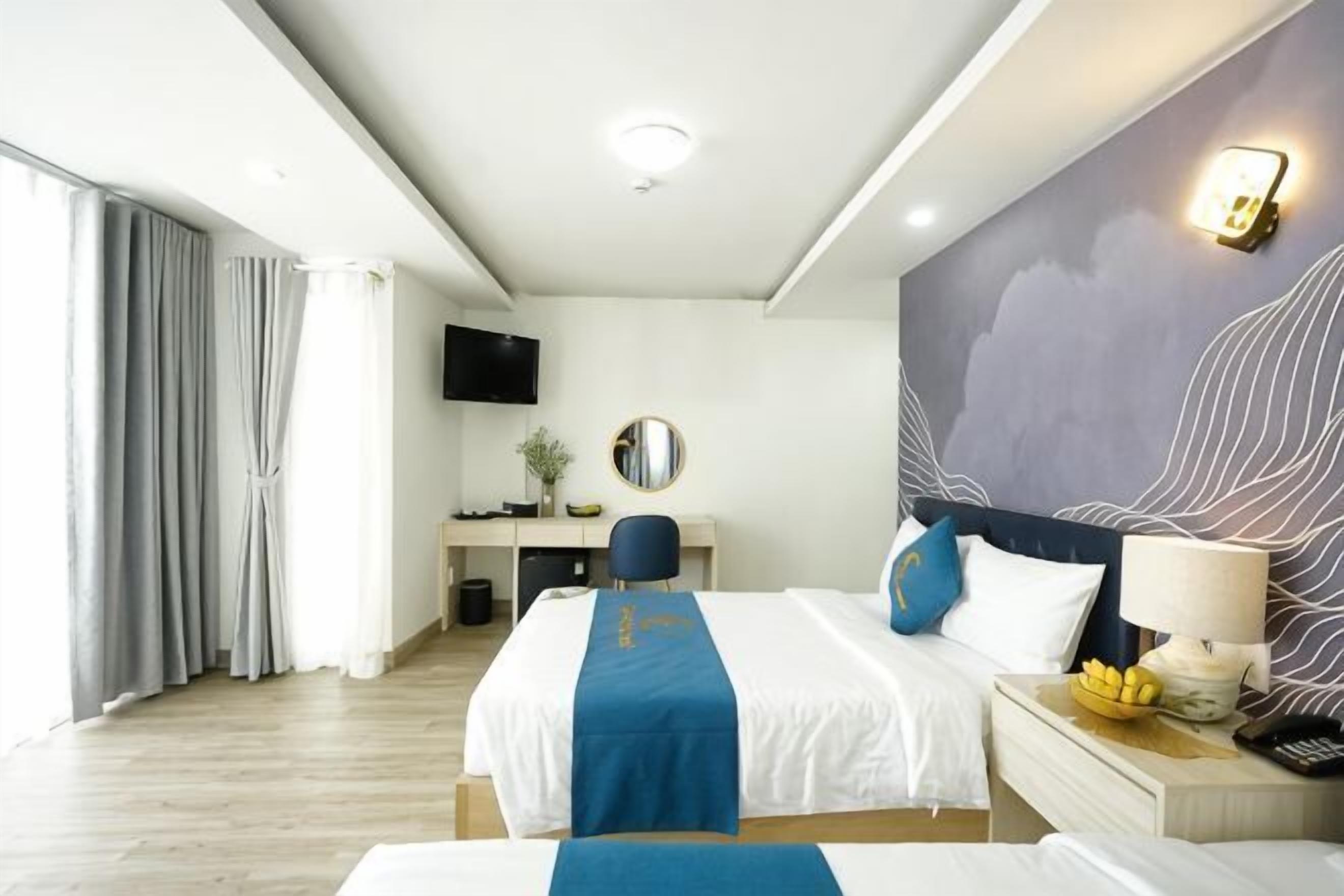 Ein Hotelzimmer mit Bett, Schreibtisch und Fernseher.