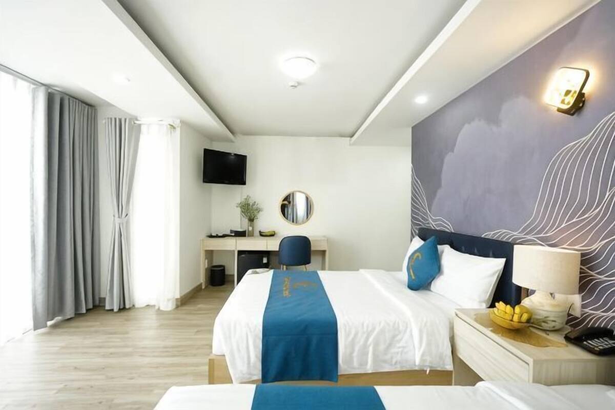 Ein Hotelzimmer mit Bett, Schreibtisch und Fernseher.
