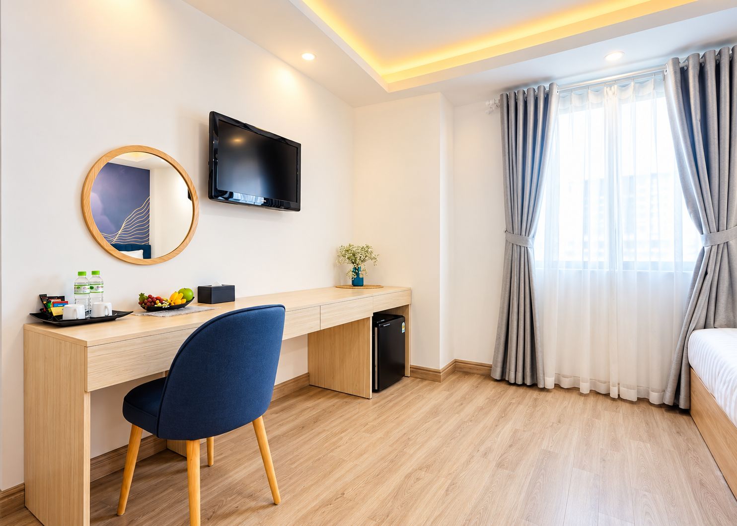 Una habitación de hotel con escritorio, silla, televisor y cama.