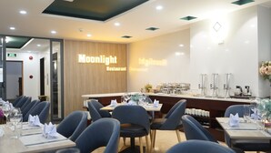 Un restaurante con una decoración moderna, que incluye una zona de bar con máquinas de café y un espacio para bufé.