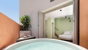 Un jacuzzi en una habitación con cama y planta.