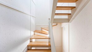 A modern staircase with wooden steps and white walls. - Cimo de Vila 62 by LovelyStay (Porto)